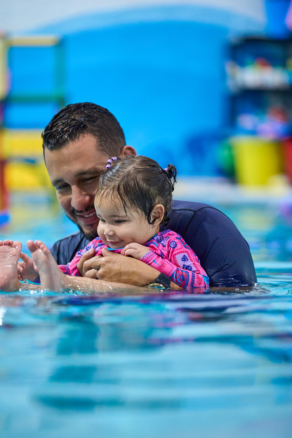 Papá sosteniendo a su bebé en el agua