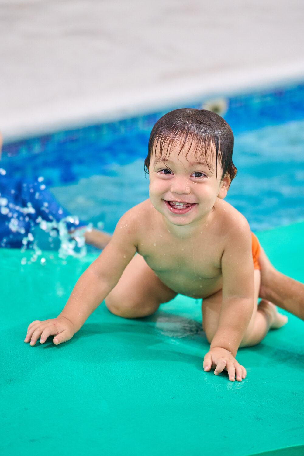 Bebé gateando en el borde de la piscina